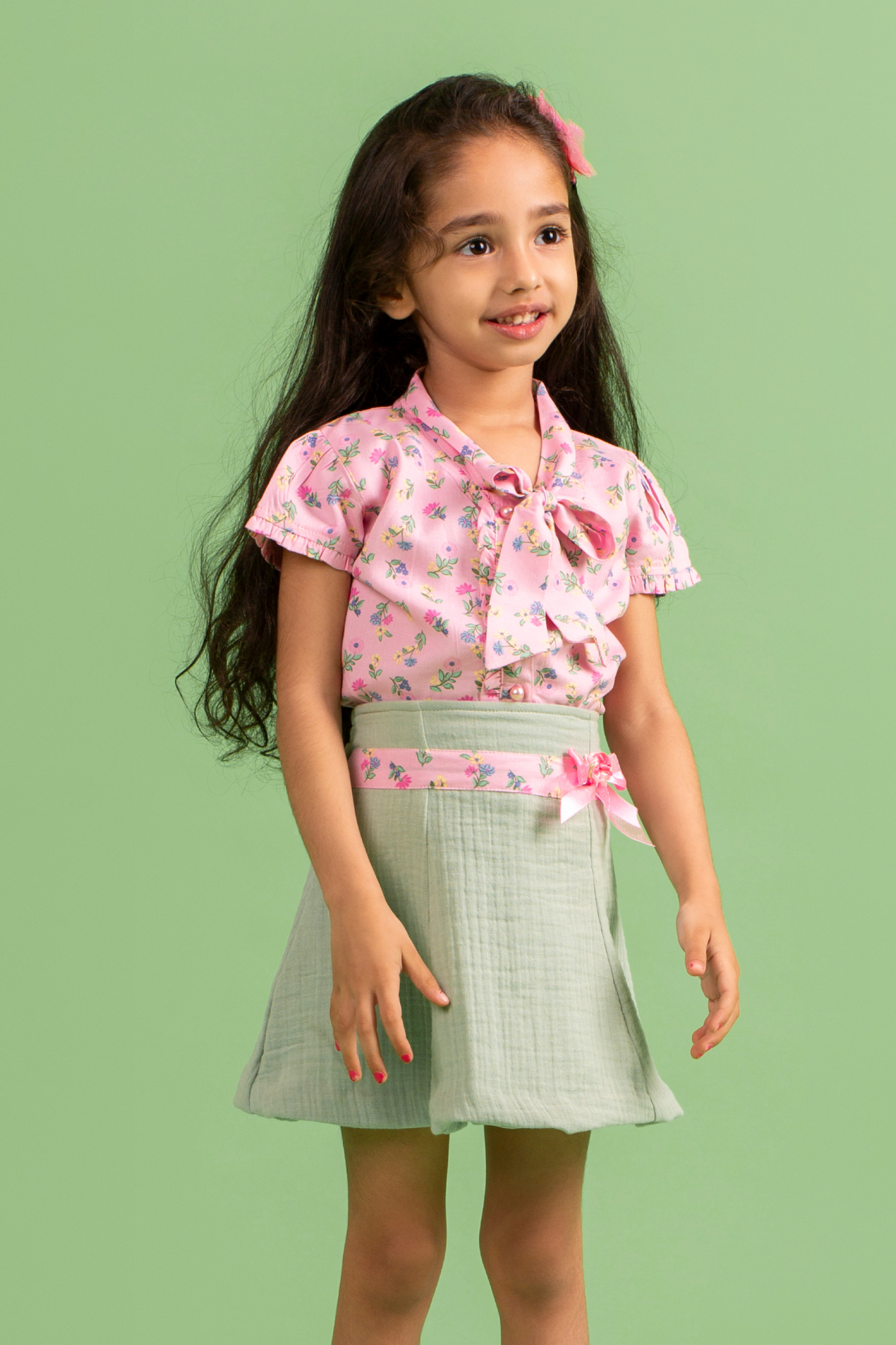 Pink printed top with tie up bow and green skirt